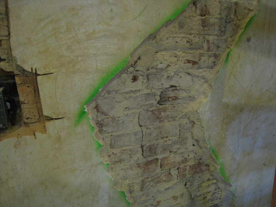 First Floor--Southeast room, detail of bare brick on north wall (by doorway)
